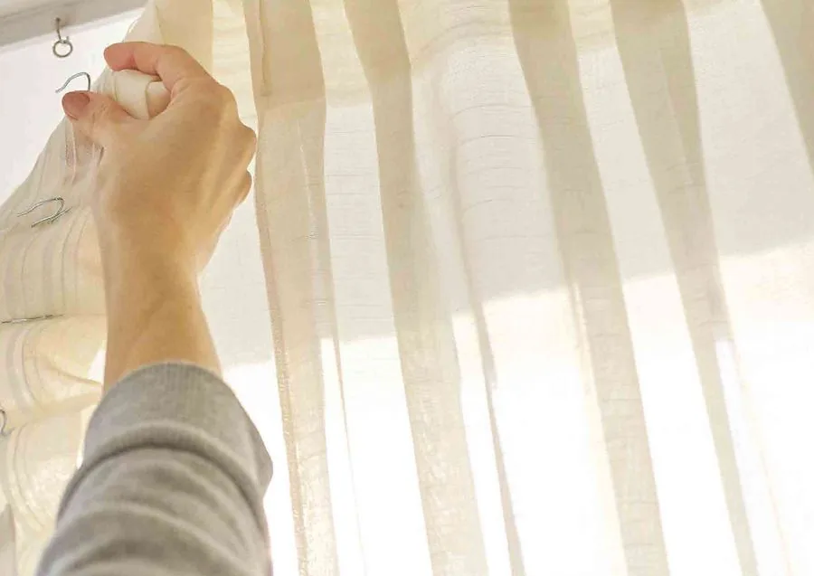 Close-up of MOWIN sheer curtain fabric being fitted to its track