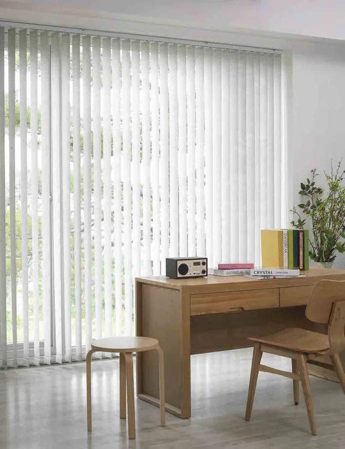 Vertical blinds controlling light on wide glass windows