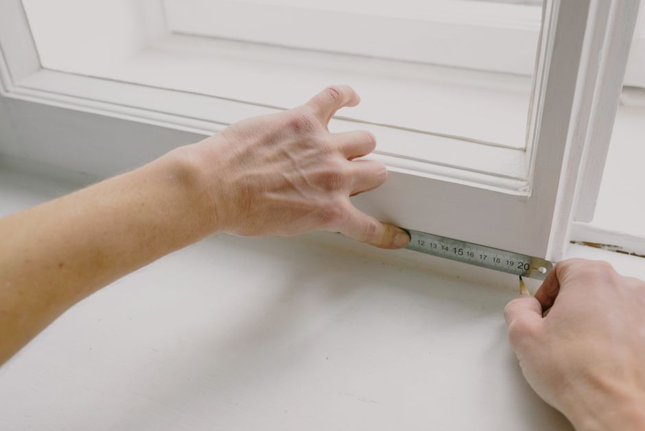 Measuring a window frame before office roller blind production